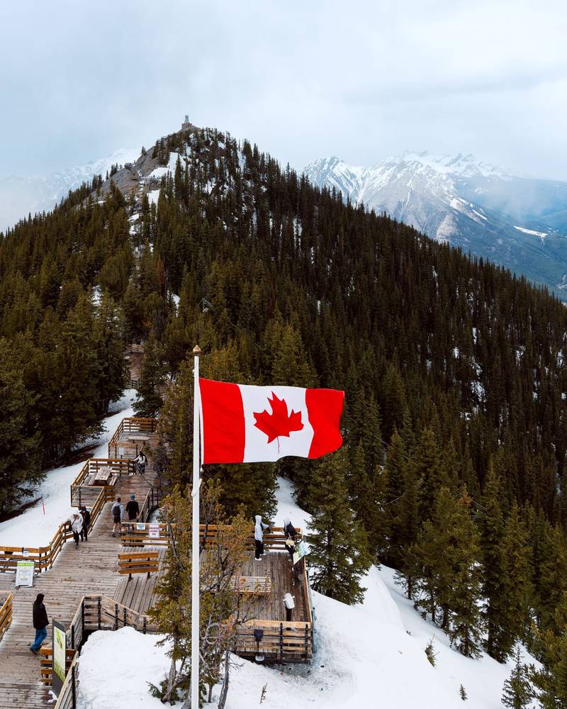 Det kanadiske flagget på Sulphur Mountain over Rocky Mountains nær Banff, Canada
