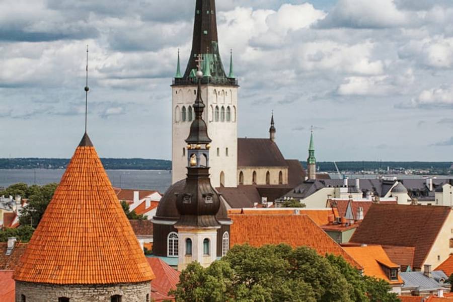 The spire of St. Olaf's Church above the red rooftops of Tallinn old town, Estonia