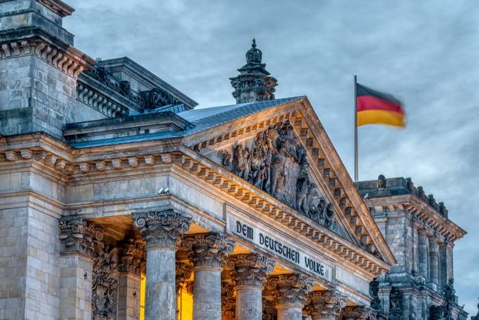 The Reichstag building with its DEM DEUTSCHEN VOLKE inscription and the German flag, Berlin, Germany