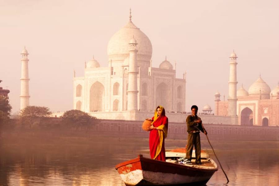 The Taj Mahal at dawn with a boat on the Yamuna river, Agra, India