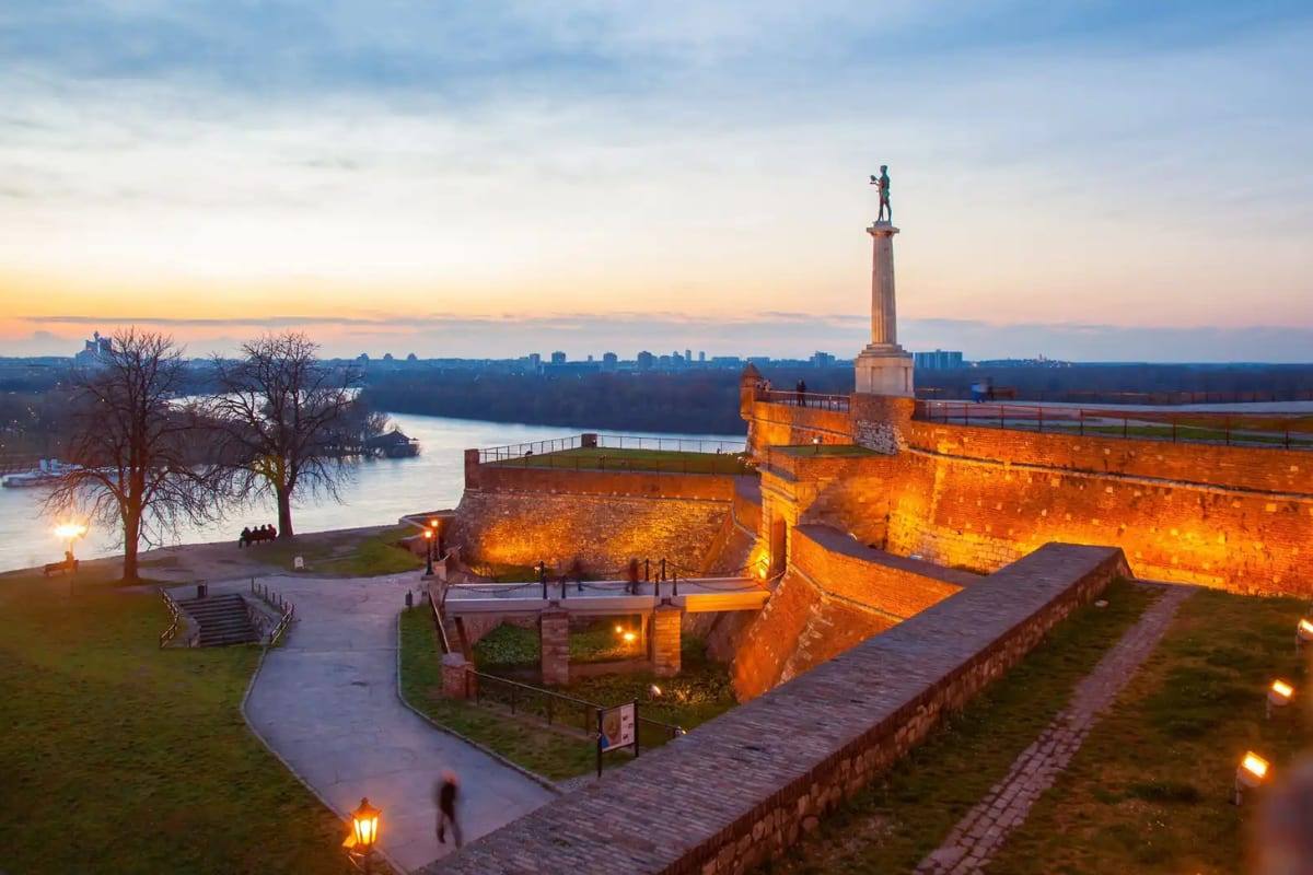 The Victor monument and Kalemegdan fortress walls above the river confluence at dusk, Belgrade, Serbia