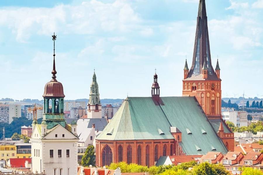 The brick tower of St. James's Cathedral above the rooftops of Szczecin, Poland