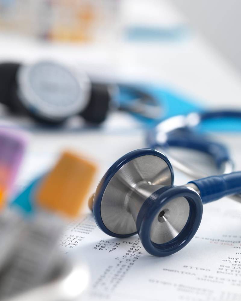 Un estetoscopio apoyado sobre unos resultados de análisis médicos impresos